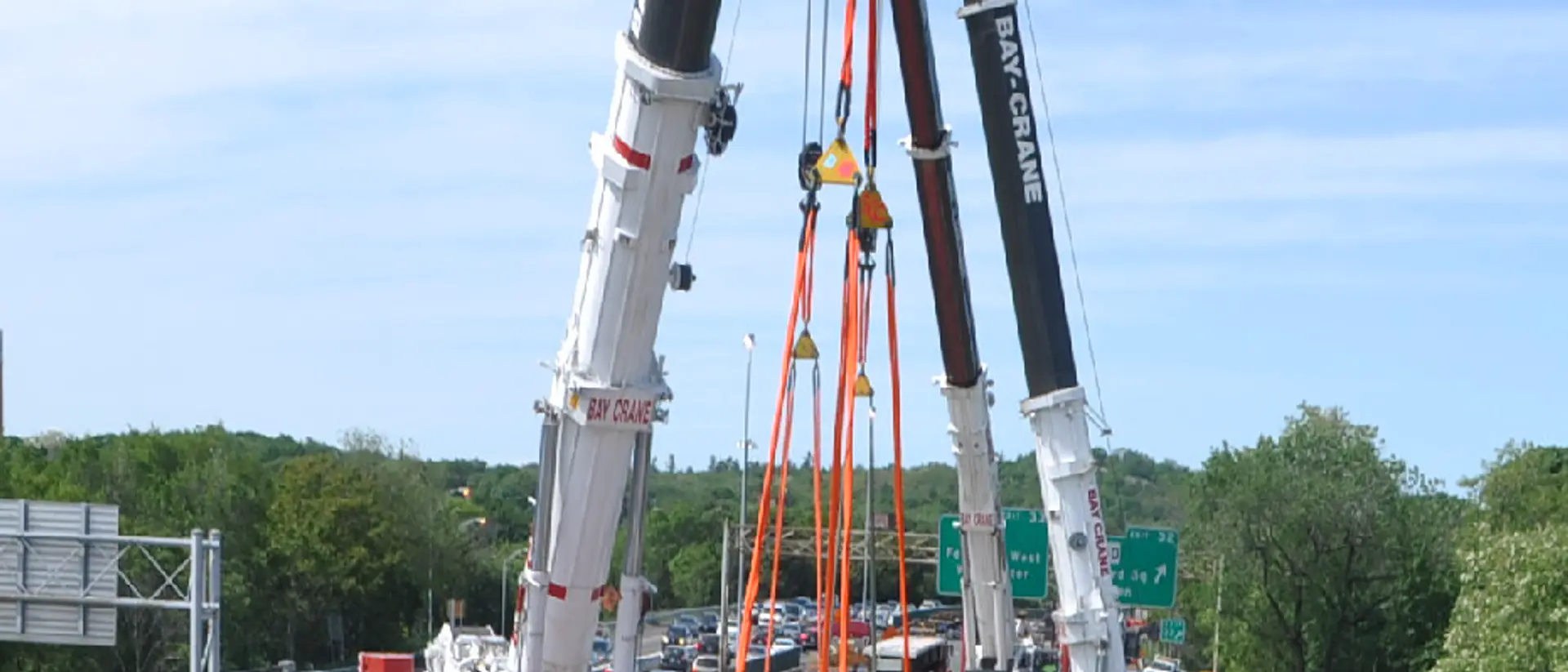 Crane setting a precast concrete bridge span on a precast concrete highway project serving Binghamton, NY