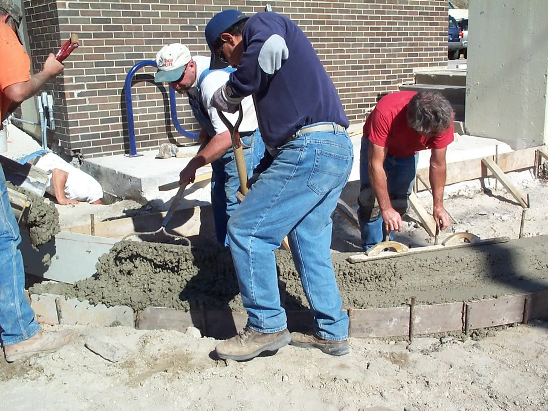 Crew hand-finishing a concrete sidewalk and curb in Binghamton, NY